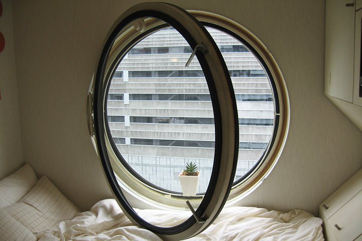 Круглое окно из дерева в спальне
